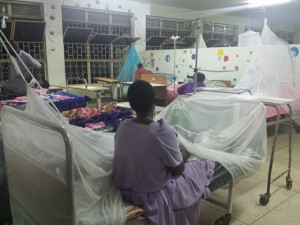 Patients under mosquito netting in the pediatric cardiology ward at night 